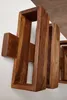 A close-up shot of a wooden shelf unit mounted on a white wall. Produktbild-Vorschau
