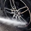 A close-up shot of a car wheel being cleaned with a spray of water. Náhled obrázku produktu