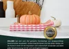 A still life arrangement of kitchen items, including pumpkins and folded dish towels, with a promotional badge and text overlay. Produktbild-Vorschau