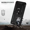 A black phone case with a ring holder is shown in a dynamic pose, appearing to be dropped onto rocky terrain. The background is blurred and suggests an outdoor, rugged environment. Produktbild-Vorschau
