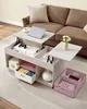 A lift-top coffee table with storage, shown in a living room setting with a sofa in the background. Náhled obrázku produktu