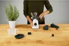 A person assembling a white and clear juicer on a wooden table. Produktbild-Vorschau