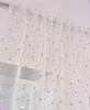 A close-up view of sheer curtains with a polka dot pattern hanging from a curtain rod. Produktbild-Vorschau