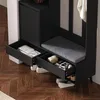 A black entryway storage unit with a bench, drawers, and a cabinet, shown with shoes and items inside the drawers. Produktbild-Vorschau
