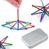 A hand holding magnetic building sticks, forming a geometric shape, with other magnetic shapes and a metal box in the background. Náhled obrázku produktu