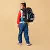 A young girl wearing a backpack and looking over her shoulder. Anteprima dell’immagine prodotto