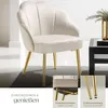 A cream-colored armchair with gold legs is shown in a room setting, next to a black coffee table. Inset images highlight the chair's construction and adjustable feet. Produktbild-Vorschau