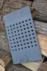 A cast iron grate with many holes is placed on a pile of firewood. Voir les images du produit
