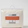 A quilted fleece mattress topper is shown inside its clear plastic packaging. Anteprima dell’immagine prodotto