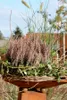 A decorative garden column with a planter filled with plants. Produktbild-Vorschau