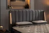 A close-up view of a bed with a padded headboard and two pillows on the mattress. The headboard has integrated lighting on the sides. Produktbild-Vorschau