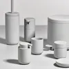 A collection of minimalist grey bathroom accessories arranged on a light grey surface. Produktbild-Vorschau