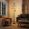 A living room scene with a floor lamp, armchair, and sofa. Produktbild-Vorschau