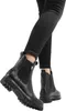 A person wearing black jeans and black boots. Produktbild-Vorschau