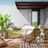 A modern outdoor lounge chair on a wooden deck with plants and lanterns. Voir les images du produit