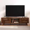 A modern TV stand with a large television on top, set against a plain wall. Produktbild-Vorschau