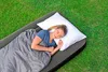 A woman sleeping on an air mattress outdoors on the grass. Náhled obrázku produktu