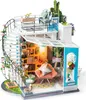 A miniature dollhouse with a spiral staircase, balcony, and interior rooms filled with furniture and plants. Anteprima dell’immagine prodotto