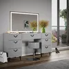 A modern vanity set with a mirror, stool, and drawers, placed in a well-lit room with a balcony view. Podgląd zdjęcia produktu