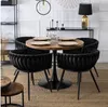 A round dining table with four black chairs in a dining room setting. Náhľad obrázku produktu