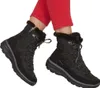 A person wearing black winter boots and red pants. Produktbild-Vorschau