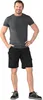 A man wearing a gray t-shirt and black shorts stands with his hands in his pockets against a white background. Produktbild-Vorschau