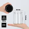 A hand holds a black lid above a glass jar, with dimensions and weight information displayed. Podgląd zdjęcia produktu
