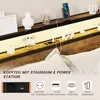 A close-up view of a bed headboard with integrated lighting and power outlets, along with decorative items and a smartphone charging. Náhled obrázku produktu