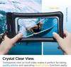 A person is holding a waterproof phone case with a phone inside, showing a surfer in the water. Podgląd zdjęcia produktu