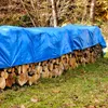 A stack of firewood covered by a blue tarp in an outdoor setting. Produktbild-Vorschau