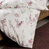 A close-up view of a floral patterned duvet cover and pillowcase on a bed. Produktbild-Vorschau