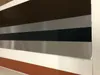 A close-up view of a metal sheet with horizontal stripes of different colors. Produktbild-Vorschau