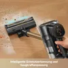 A hand holding a cordless vacuum cleaner on a wooden floor, with dirt being vacuumed up. Voir les images du produit
