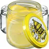 A close-up view of glass jars filled with lemon slices, with one lid featuring a bee design. Podgląd zdjęcia produktu