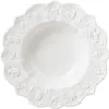A white ceramic bowl with a scalloped edge, decorated with embossed Christmas-themed motifs and stars. Náhľad obrázku produktu