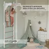 Two young girls playing on a wooden climbing frame in a child's room. Voir les images du produit