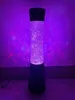 A tall, cylindrical decorative lamp with purple glittery liquid and lights. Anteprima dell’immagine prodotto