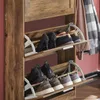 A wooden shoe cabinet with multiple shelves holding various shoes. Produktbild-Vorschau