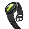 A close-up, angled shot of a black smartwatch with a green and yellow watch face, set against a white background. Náhled obrázku produktu