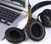 A pair of black headphones and a laptop are placed next to a miniature Eiffel Tower. Podgląd zdjęcia produktu