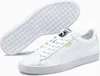 A pair of white Puma sneakers is shown from a slightly elevated angle, with one shoe in the foreground and the sole of the other shoe visible in the background. Anteprima dell’immagine prodotto
