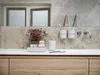 A modern bathroom sink area with a toothbrush holder, soap dispenser, and a small plant. Produktbild-Vorschau