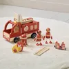 A wooden toy fire truck with accessories and two toy firefighters on a white rug. Produktbild-Vorschau
