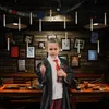 A young person dressed as a wizard stands in front of a wall decorated with framed pictures and floating LED candles. Náhľad obrázku produktu