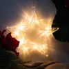 A close-up shot of a star-shaped LED light decoration, likely for Christmas, with a red flower and pine branches in the foreground. Produktbild-Vorschau