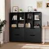 A black wooden bookshelf with multiple compartments and drawers, filled with books and decorative items, placed in a room with a window and curtains. Podgląd zdjęcia produktu