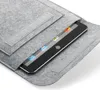A tablet is partially inserted into a grey felt sleeve. Produktbild-Vorschau