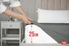 A person is putting a fitted sheet on a mattress, showing the depth of the sheet. Produktbild-Vorschau
