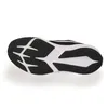 The underside of a black and white Nike sneaker. Voir les images du produit