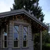 A wooden cabin decorated with warm white LED string lights along the roofline. Podgląd zdjęcia produktu